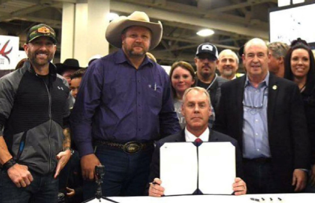 Ryan Zinke holding sectorial order with group of supporters